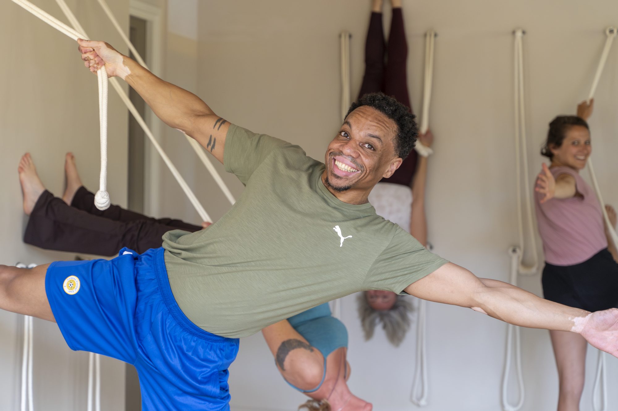 Iyengar-les in Thrive Celebes: cursist werkt met de touwen aan de wand